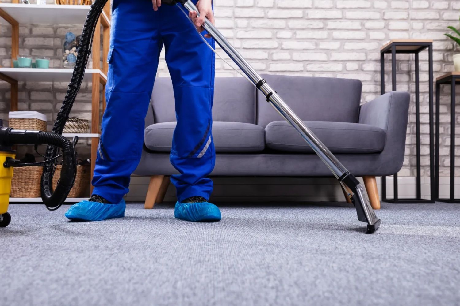 A man in blue overalls is engaged in carpet cleaning, highlighting a service located in Miami, FL.